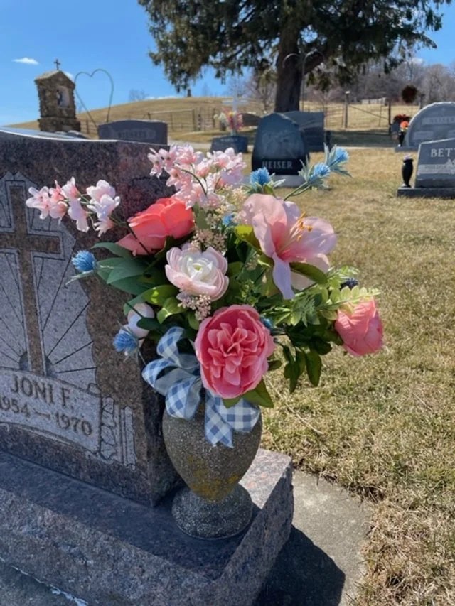 Real blush roses, gerbera daisies and mixed flowers arranged in a graveside vase